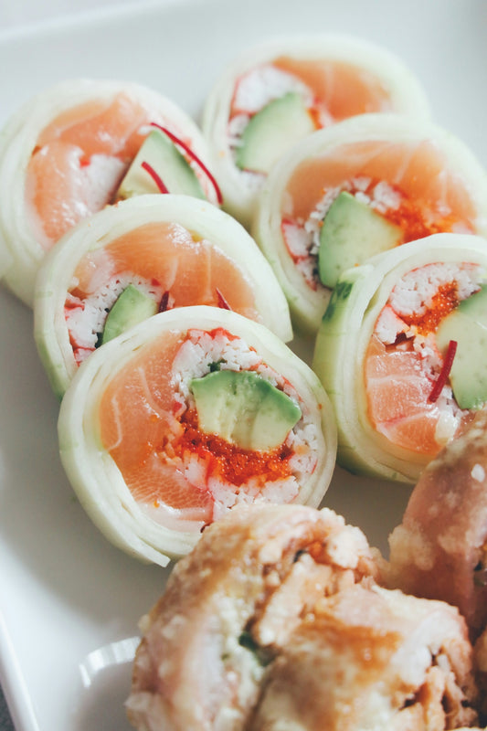 a white plate topped with rolls covered in cucumbers