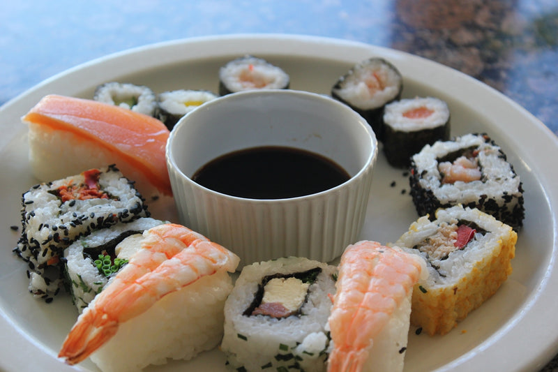 a white plate topped with sushi and sauce