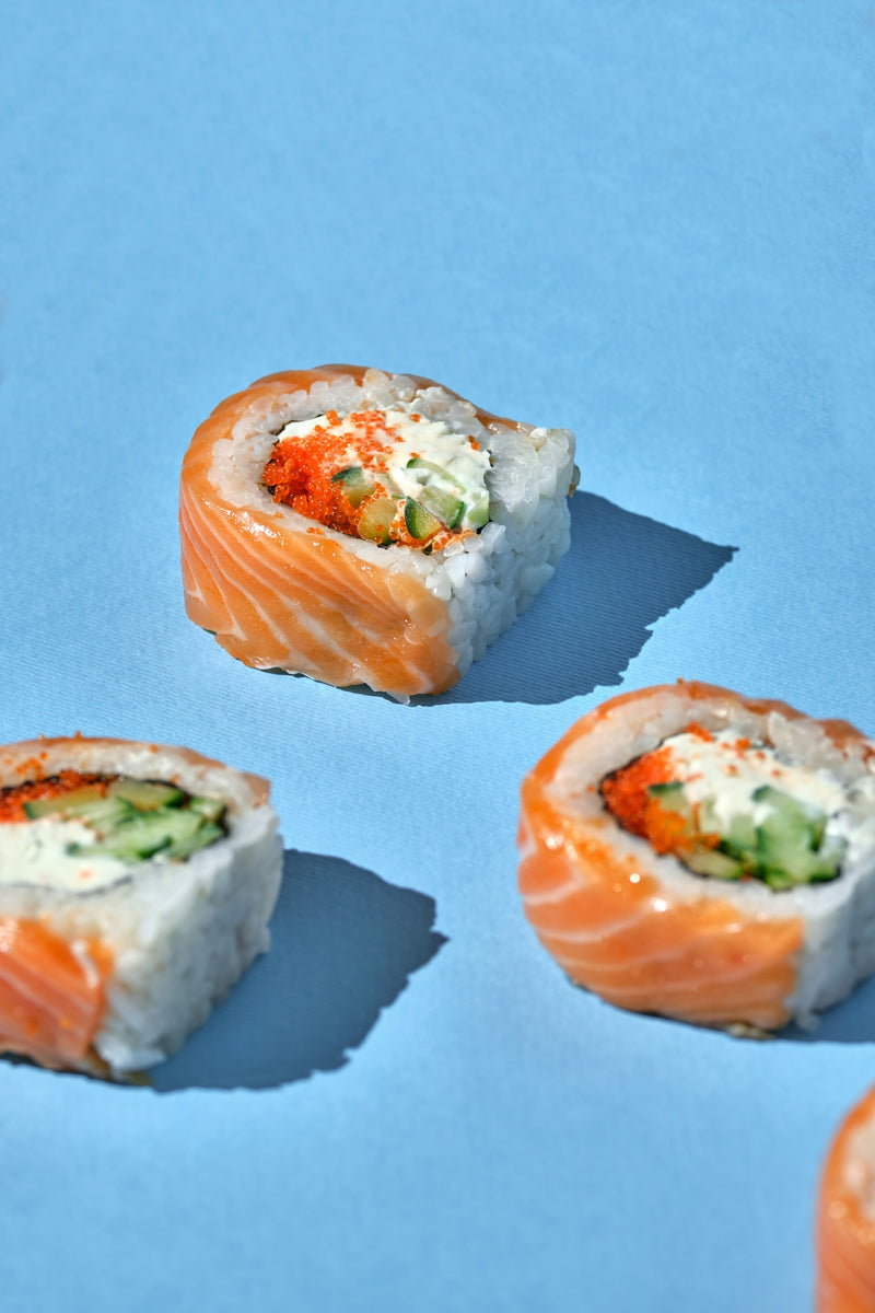a group of sushi rolls sitting on top of a blue surface