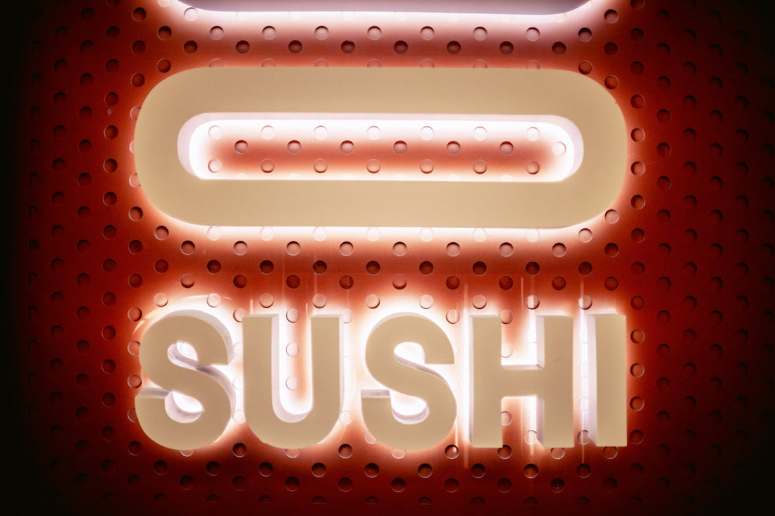 a close up of a neon sign that says sushi