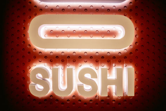 a close up of a neon sign that says sushi