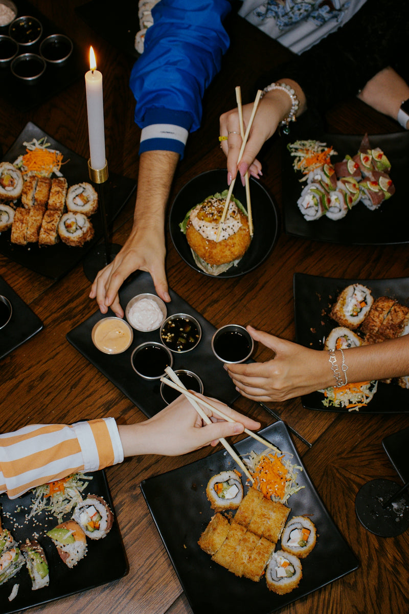 A group of people sitting around a table eating sushi