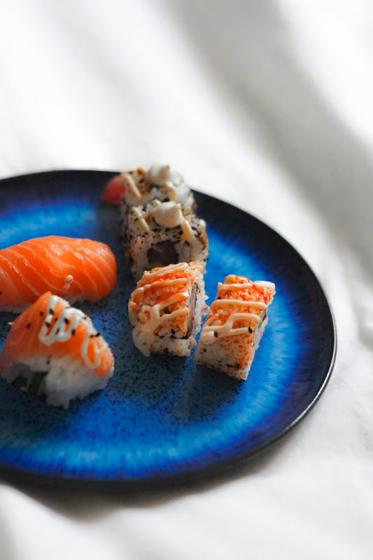A blue plate topped with sushi and carrots