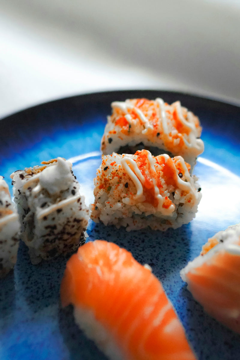 A blue plate topped with sushi and rolls