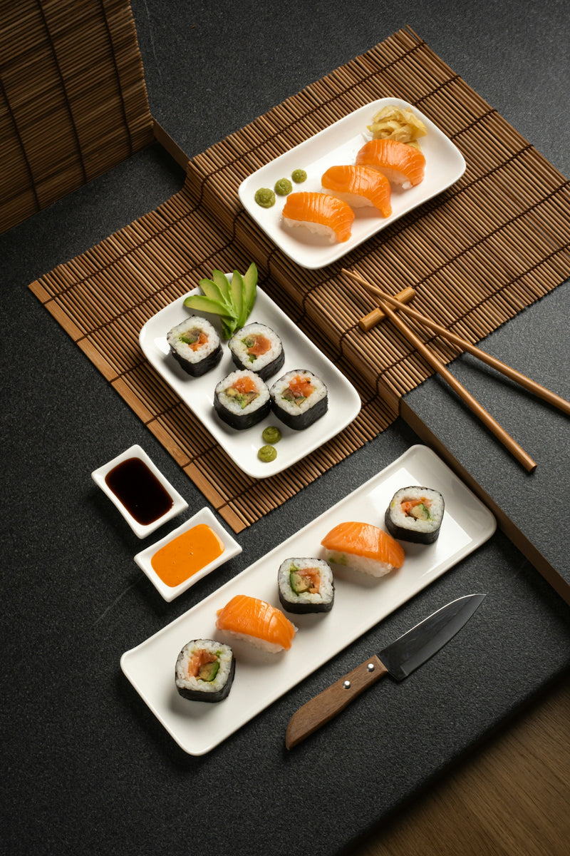 A table topped with plates of sushi and chopsticks