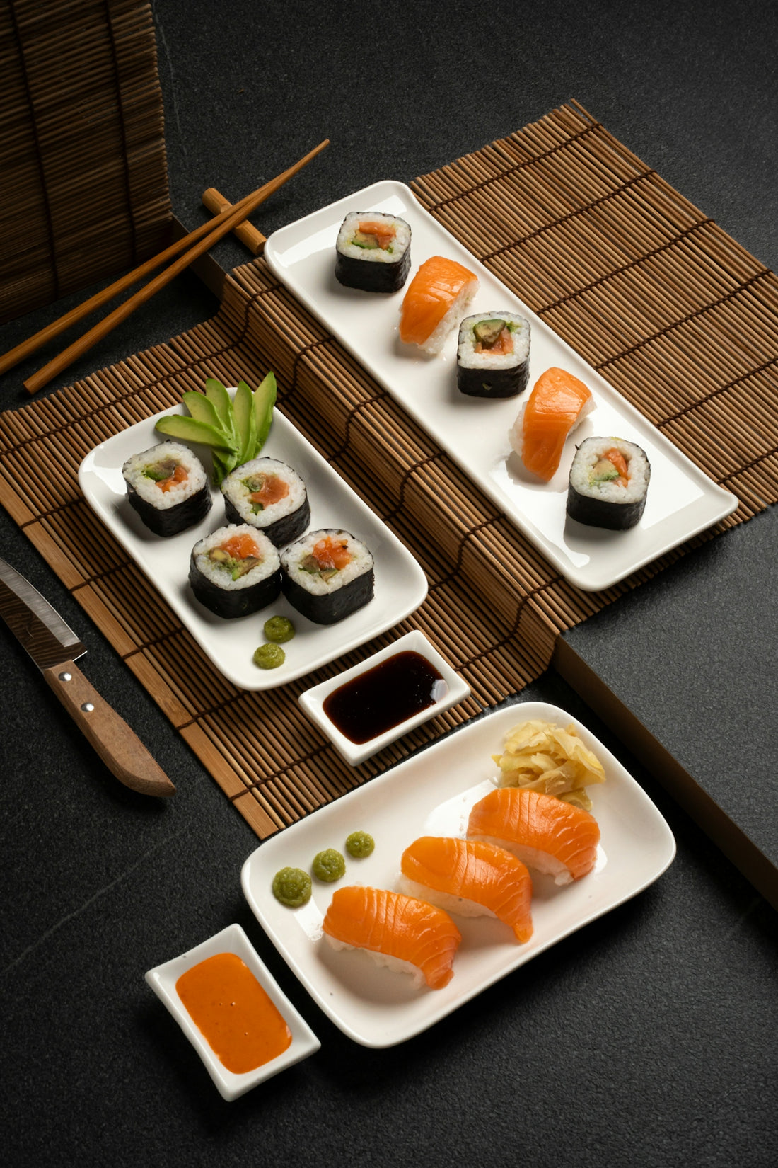A table topped with plates of sushi and chopsticks