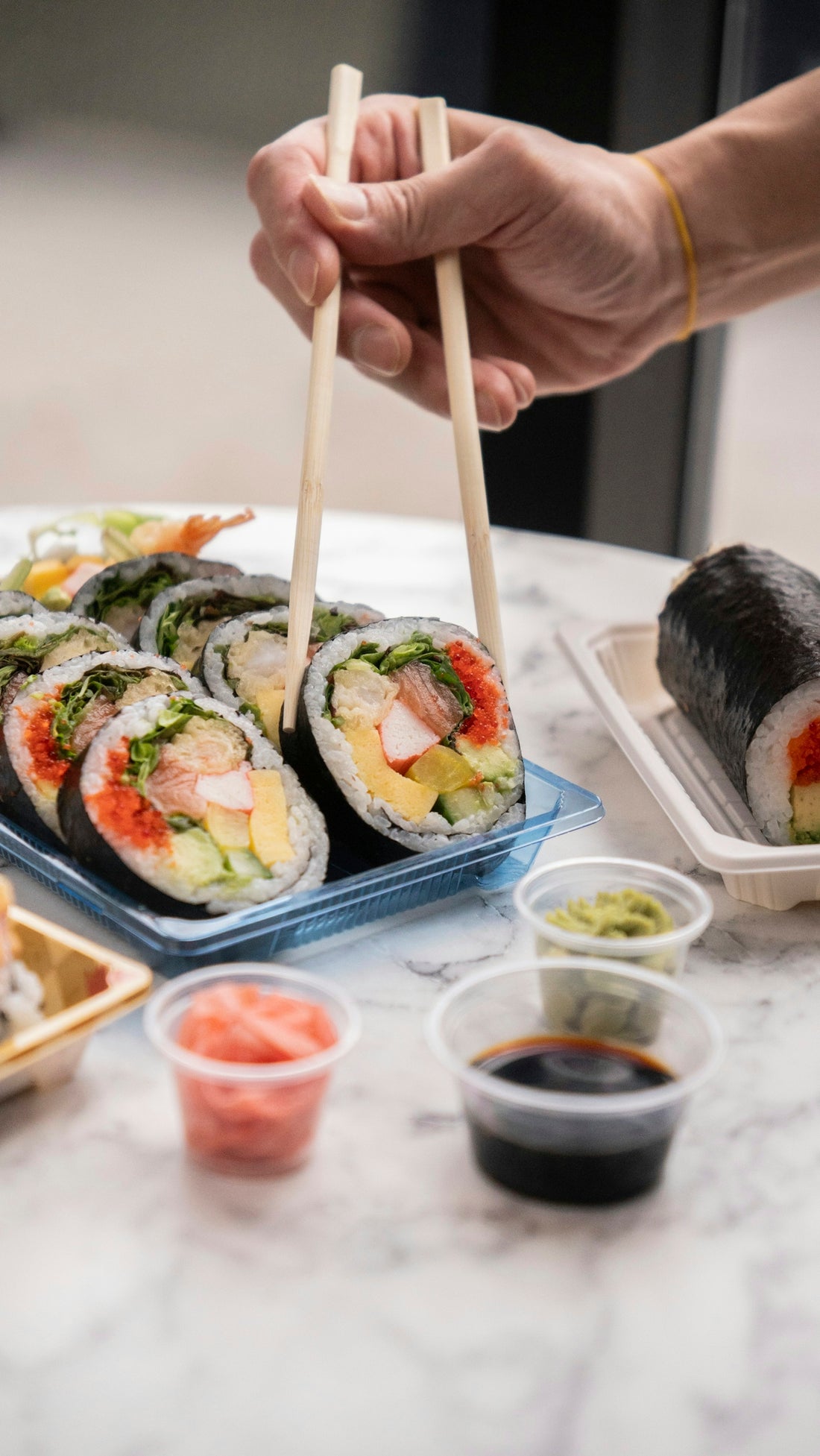 Someone using chopsticks to eat sushi.